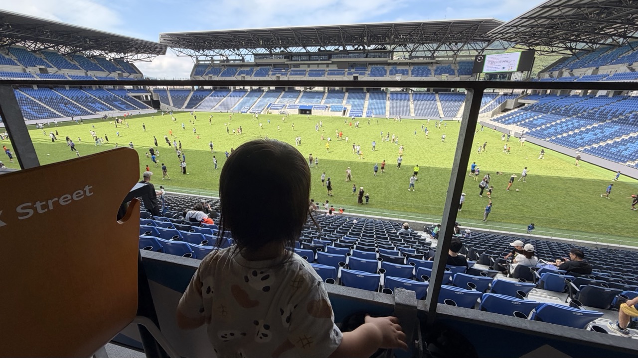スタンドからピッチを見つめる子ども